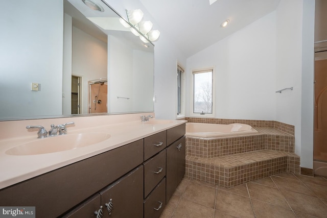 bathroom with double vanity, lofted ceiling, tile patterned floors, a sink, and a bath