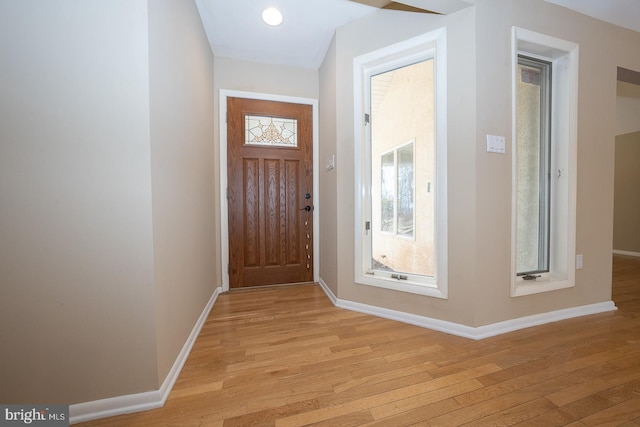 entryway featuring light wood finished floors, a wealth of natural light, and baseboards