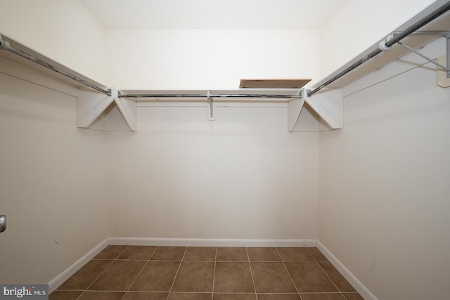 walk in closet with dark tile patterned floors