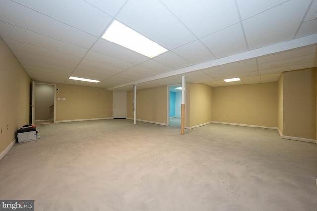 finished basement with a drop ceiling and baseboards