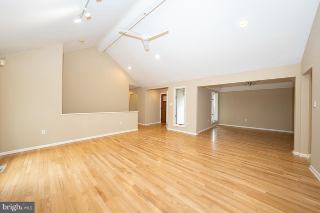 unfurnished living room with beam ceiling, rail lighting, high vaulted ceiling, light wood-type flooring, and baseboards