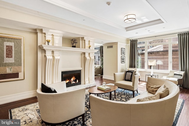 130 S 18th St Unit 2502, Philadelphia, PA 19103 - living area with a warm lit fireplace, a tray ceiling, baseboards, ornamental molding, and wood finished floors