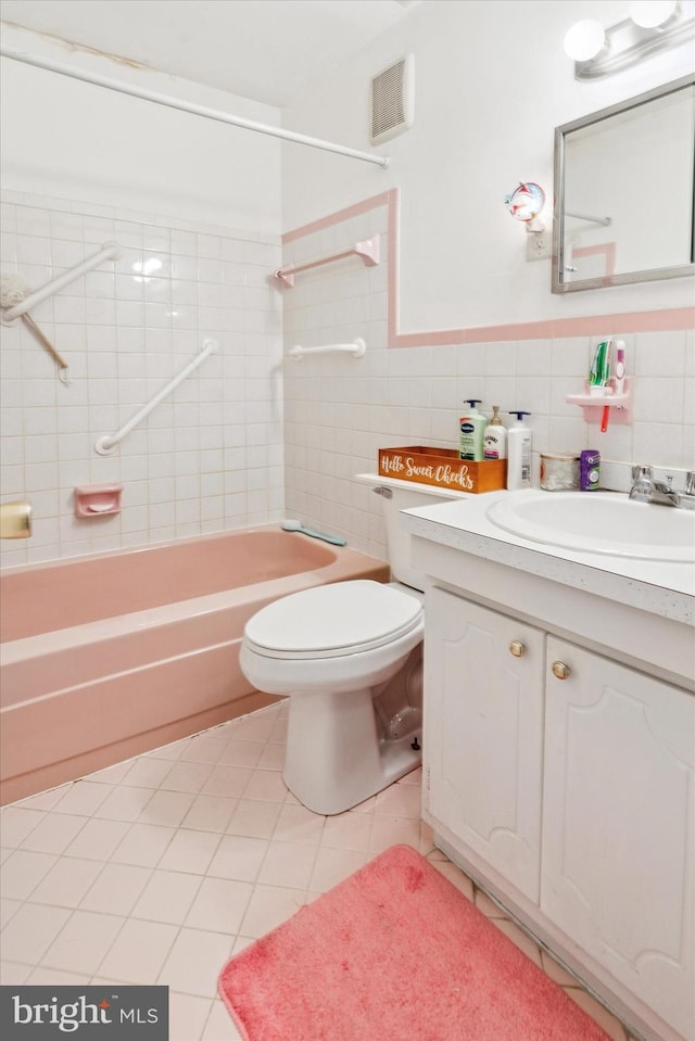 full bath with shower / bathtub combination, tile patterned flooring, visible vents, vanity, and tile walls