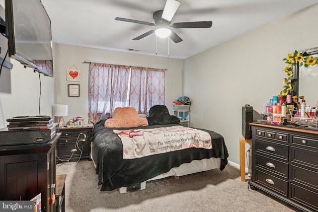 bedroom featuring light carpet and a ceiling fan