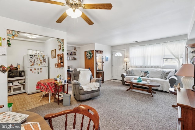 living room featuring ceiling fan and visible vents