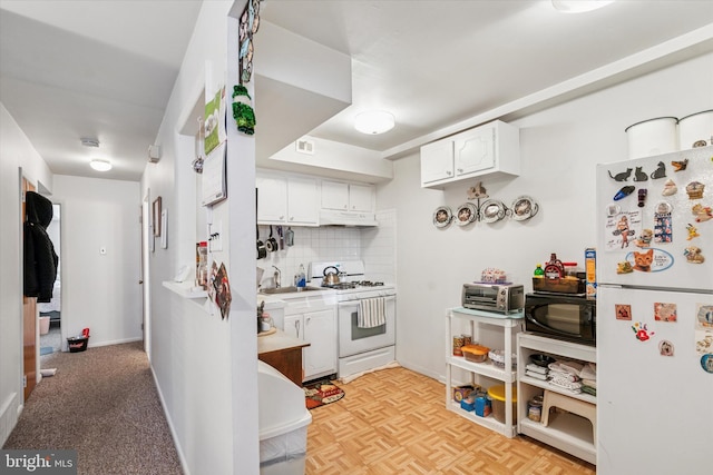 kitchen featuring white appliances, decorative backsplash, under cabinet range hood, white cabinetry, and a sink