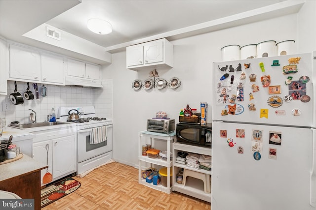 kitchen with under cabinet range hood, white appliances, a sink, white cabinets, and backsplash