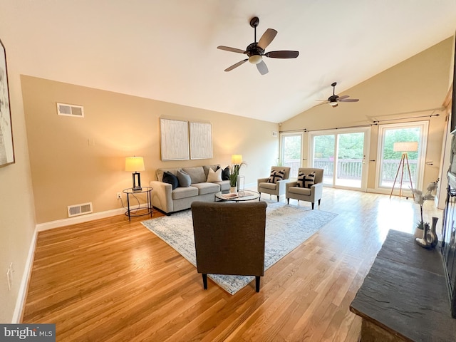 living area with lofted ceiling, baseboards, visible vents, and light wood-type flooring