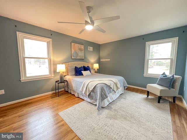 bedroom with a ceiling fan, baseboards, and wood finished floors