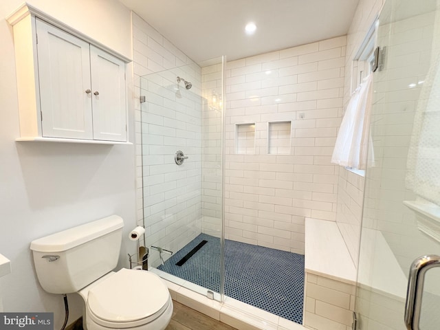 bathroom featuring toilet, recessed lighting, and a stall shower