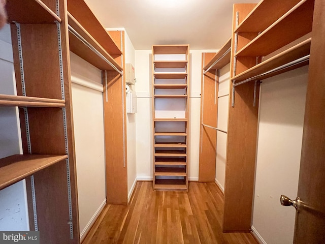 walk in closet with wood finished floors