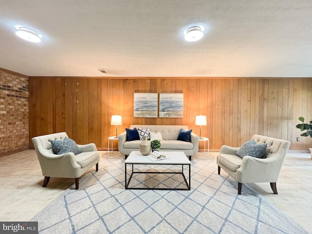 living room featuring visible vents, wood walls, and a textured ceiling