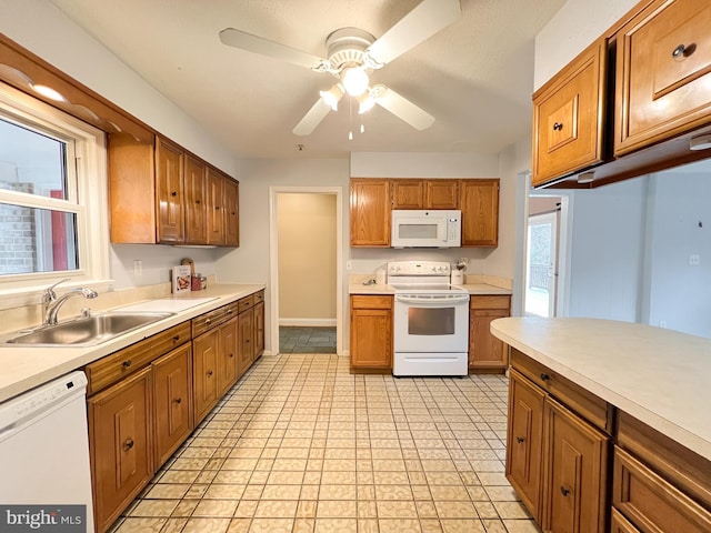 kitchen with a sink, white appliances, and light countertops