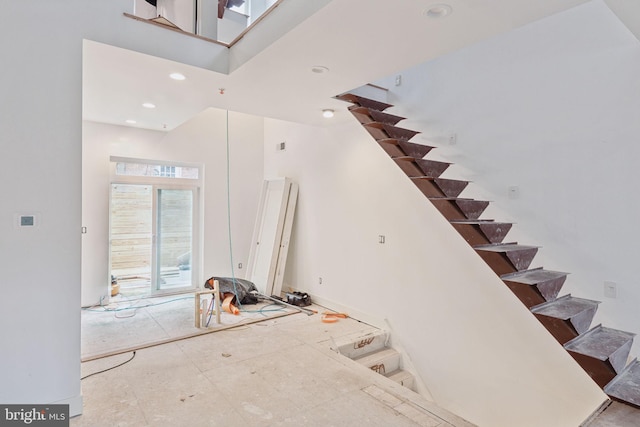 stairs with recessed lighting and a towering ceiling