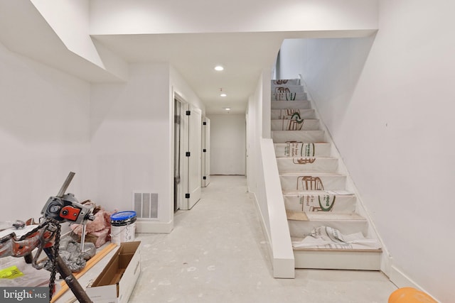 stairs with recessed lighting, visible vents, baseboards, and unfinished concrete floors