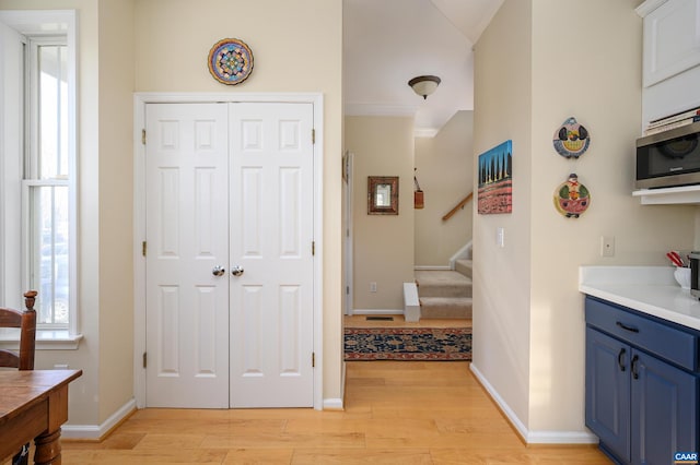 interior space with light countertops, light wood-style floors, stainless steel microwave, and blue cabinets