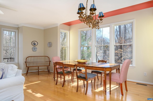 dining room with a chandelier, visible vents, baseboards, light wood finished floors, and crown molding