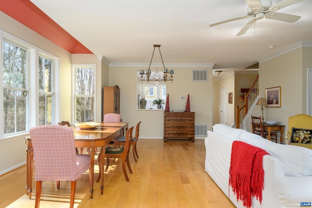 dining room featuring light wood-style floors, stairs, visible vents, and ornamental molding