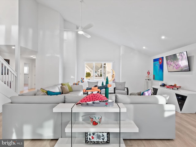 living room featuring recessed lighting, stairway, light wood-style flooring, ceiling fan, and high vaulted ceiling