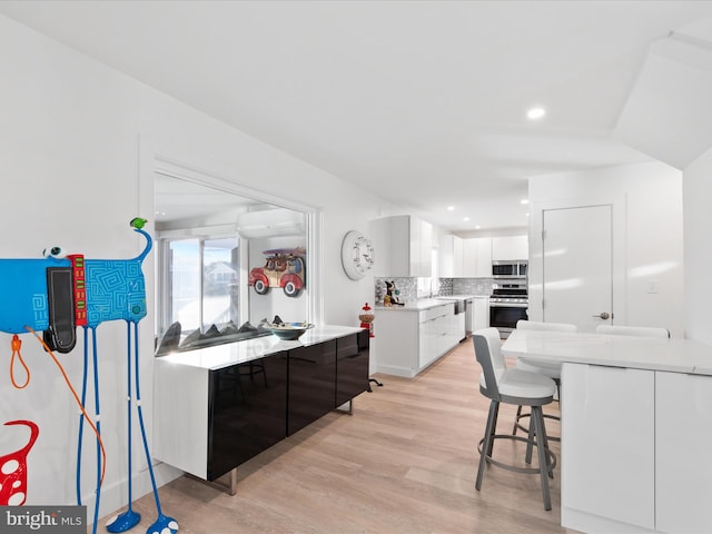 kitchen featuring tasteful backsplash, modern cabinets, appliances with stainless steel finishes, and white cabinets