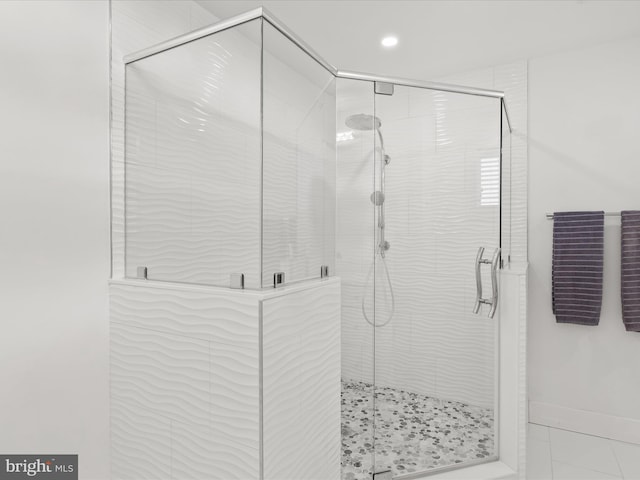 bathroom featuring a shower stall and baseboards