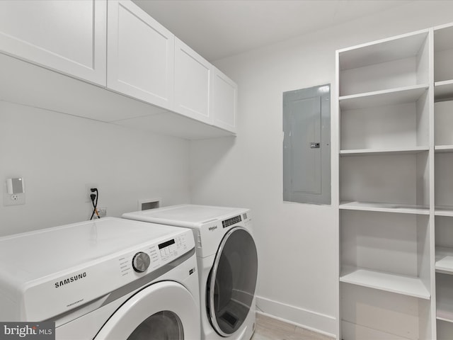 washroom with cabinet space, electric panel, baseboards, light wood-type flooring, and separate washer and dryer