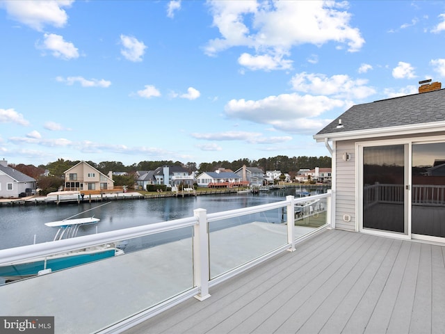 wooden terrace with a water view and a residential view