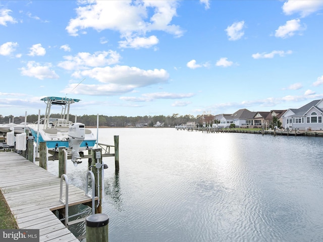 dock area with a water view, boat lift, and a residential view