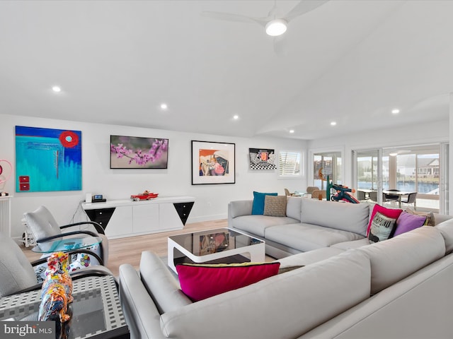 living room featuring lofted ceiling, baseboards, recessed lighting, and wood finished floors