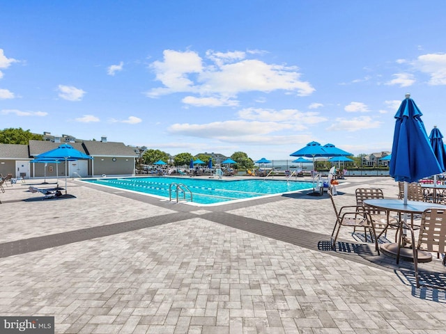 pool with a patio area and fence