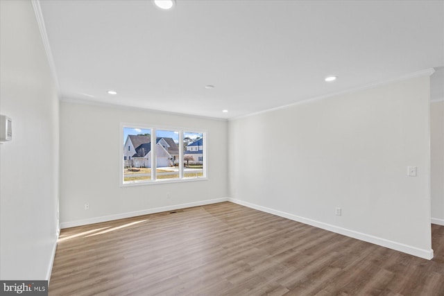 empty room with ornamental molding, recessed lighting, baseboards, and wood finished floors