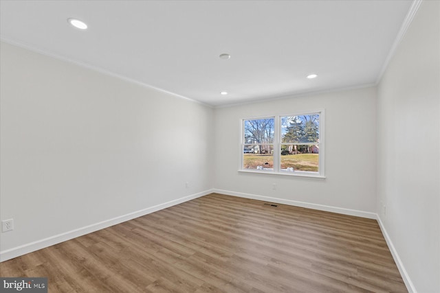 empty room with recessed lighting, wood finished floors, visible vents, baseboards, and crown molding