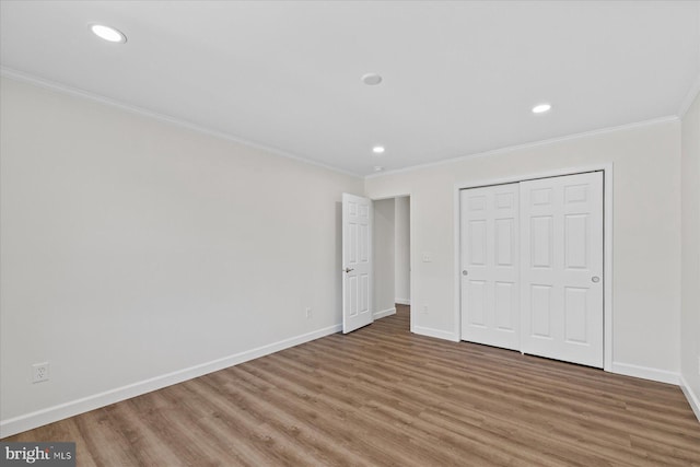 unfurnished bedroom with baseboards, ornamental molding, wood finished floors, and recessed lighting