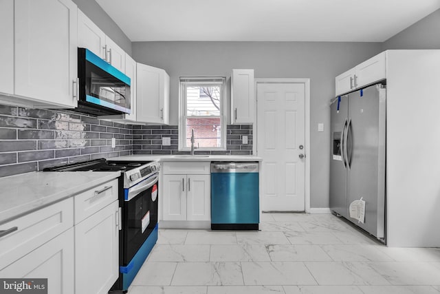 5717 Addison St, Philadelphia, PA 19143 - kitchen with appliances with stainless steel finishes, a sink, light marble finish floors, and white cabinetry