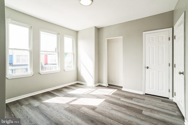 5717 Addison St, Philadelphia, PA 19143 - empty room with healthy amount of natural light, wood finished floors, and baseboards
