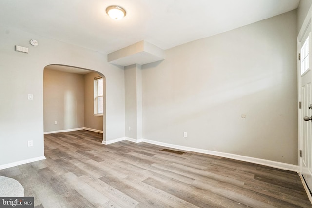 5717 Addison St, Philadelphia, PA 19143 - unfurnished room with arched walkways, wood finished floors, baseboards, and a smoke detector