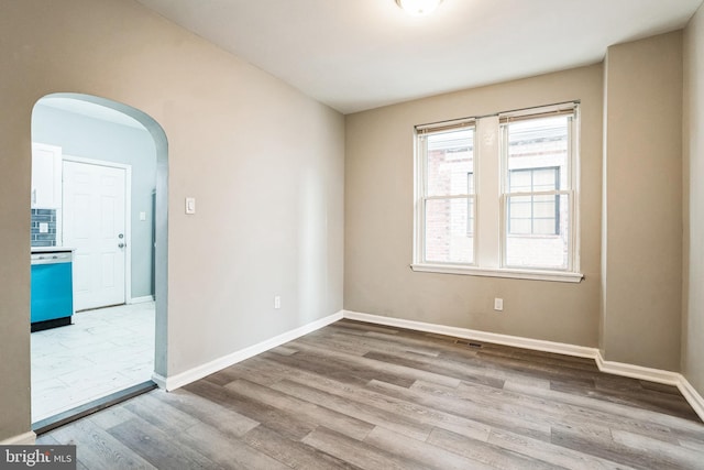 5717 Addison St, Philadelphia, PA 19143 - empty room with arched walkways, wood finished floors, and baseboards