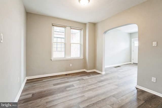 5717 Addison St, Philadelphia, PA 19143 - empty room with arched walkways, wood finished floors, and baseboards