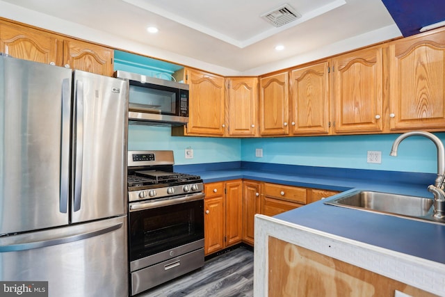 kitchen featuring dark wood-style floors, stainless steel appliances, recessed lighting, visible vents, and a sink