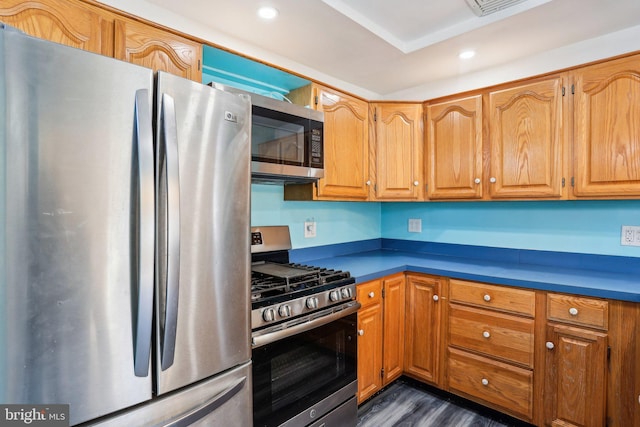 kitchen featuring brown cabinetry, dark wood-style floors, stainless steel appliances, and recessed lighting