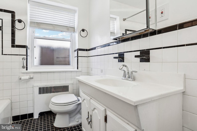 bathroom featuring tile walls, radiator, toilet, vanity, and tile patterned flooring