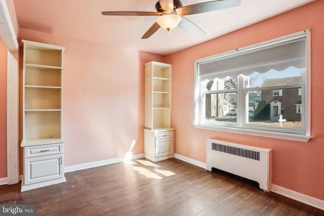 interior space featuring baseboards, dark wood finished floors, and radiator heating unit