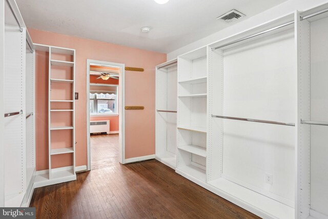 walk in closet featuring dark wood-style floors, radiator heating unit, and visible vents