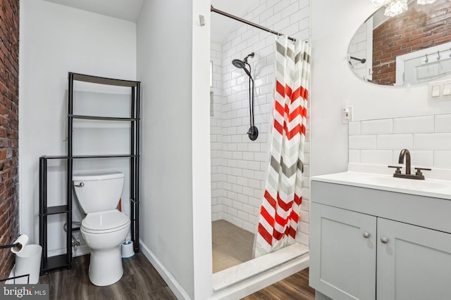 bathroom featuring vanity, a shower stall, toilet, and wood finished floors