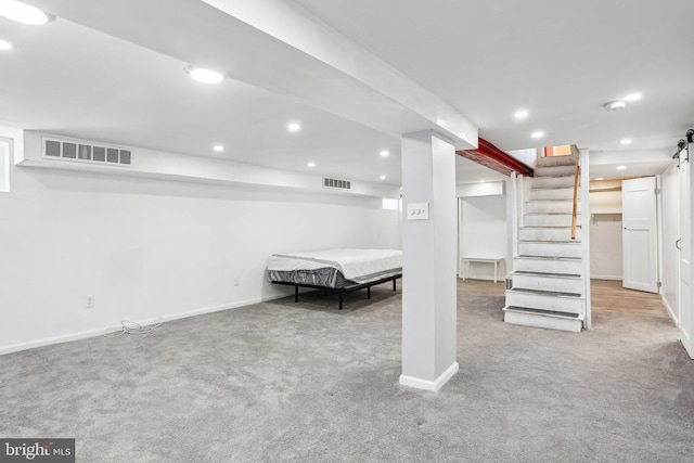 finished basement featuring carpet floors, stairway, visible vents, and recessed lighting