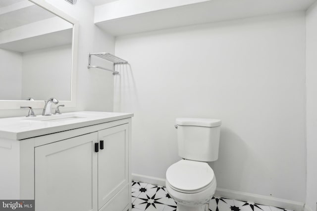 bathroom with vanity, toilet, and baseboards