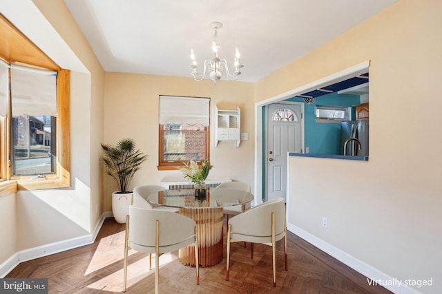 dining space featuring baseboards and a chandelier