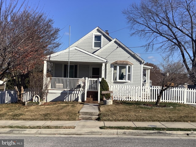 bungalow-style home featuring a porch and a fenced front yard