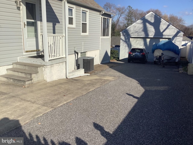 view of home's exterior featuring an outbuilding, a detached garage, and central AC unit