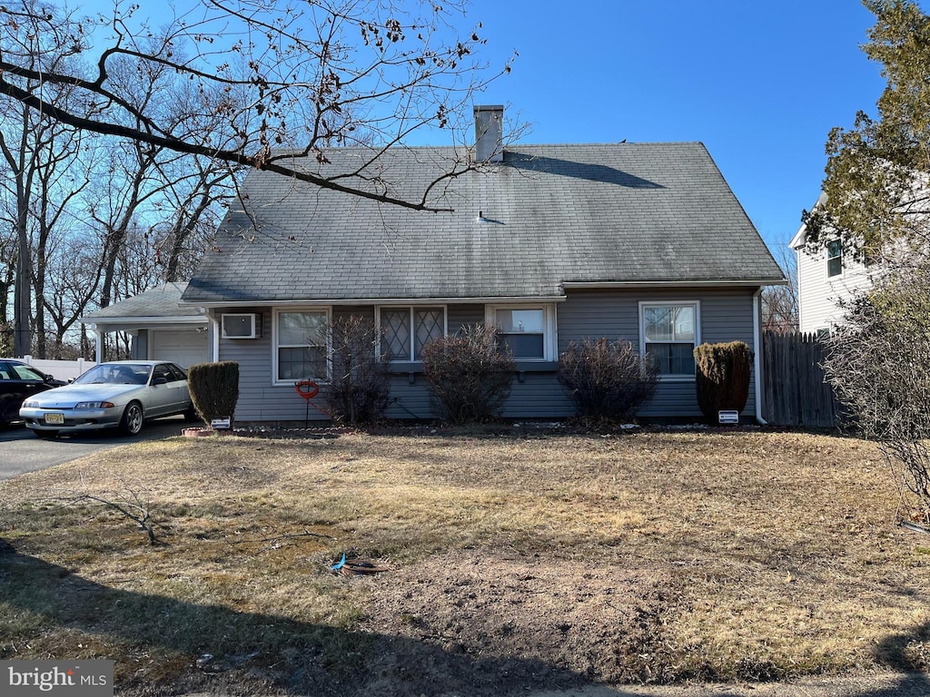 view of front of house with aphalt driveway, a chimney, a shingled roof, an attached garage, and fence